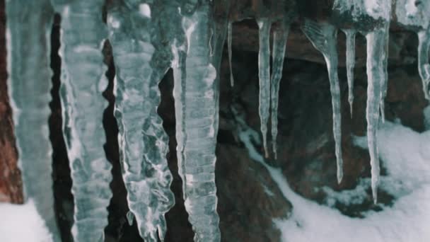 Řady rampouch visí na okraji skalnatého útesu — Stock video