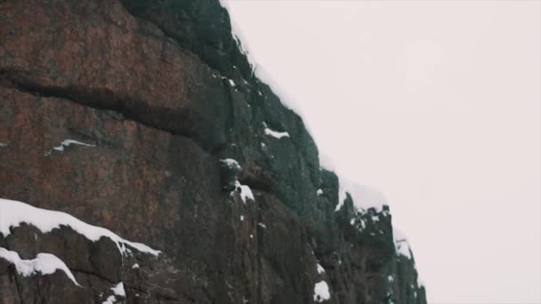 Rotswand van berg heuvel bedekt met sneeuw op de winterdag — Stockvideo