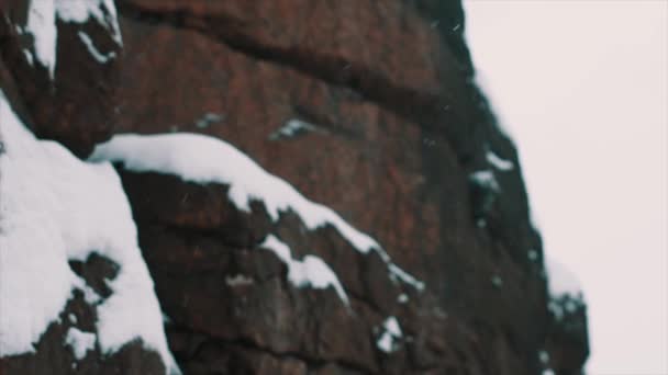 Скеляста сторона гірського пагорба вкрита снігом в зимовий день — стокове відео