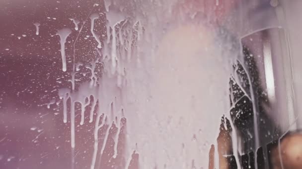 Menina sexy no chuveiro cabine esfregar leite fora de vidro — Vídeo de Stock