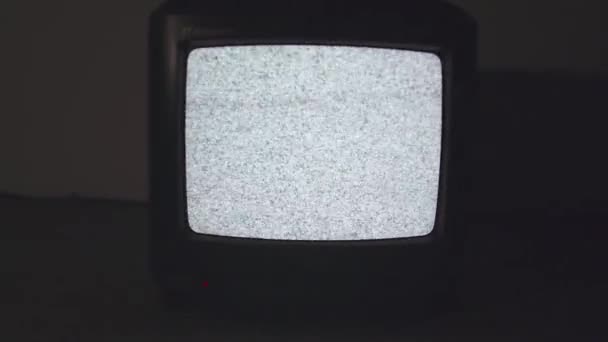 Ancien style TV écran statique sur le sol dans la pièce sombre clignotant lumière — Video