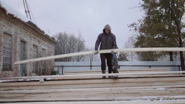 Pesado llevando tabla de madera en el patio de la fábrica de aserraderos en el día de invierno — Vídeos de Stock