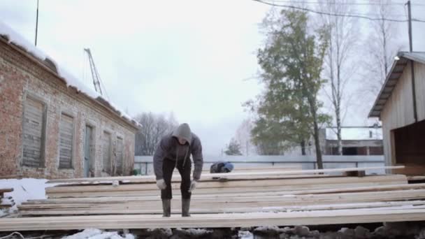 Werknemer die houten bord op zagerij fabriek werf winterdag — Stockvideo