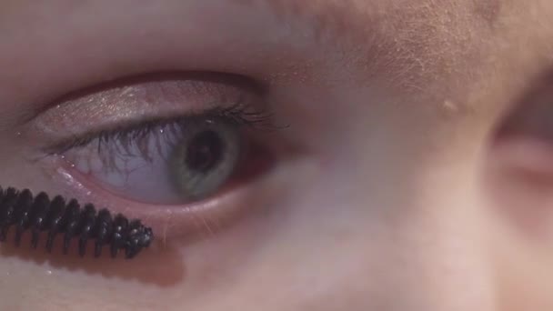 Groene ogen vrouw zet zwarte cosmetica mascara op wimper — Stockvideo