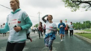 Neşeli orta yaşlı kadın dalgalar maraton kamera