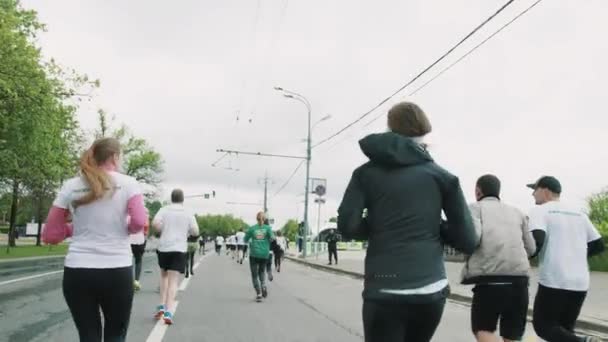 Atrás de atletas correndo maratona, menina com anjo decorativo — Vídeo de Stock