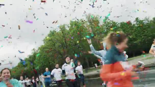 Confete colorido cai na maratona de corrida atletas alegres — Vídeo de Stock