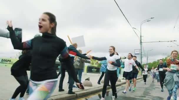 Chicas atractivas y hombres jóvenes corredores aplaude las manos de espuma en los fans — Vídeo de stock