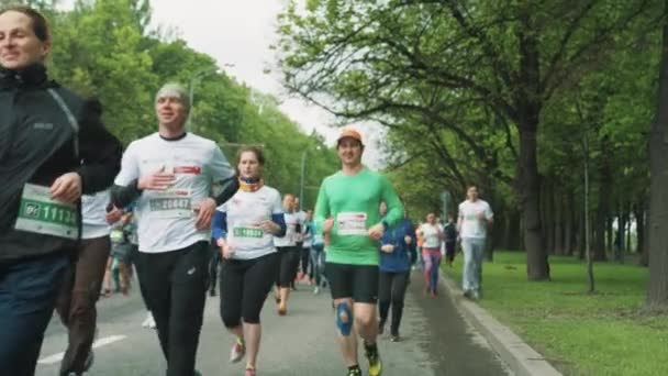 Смешной человек бежит марафон в толпе машет перед камерой — стоковое видео