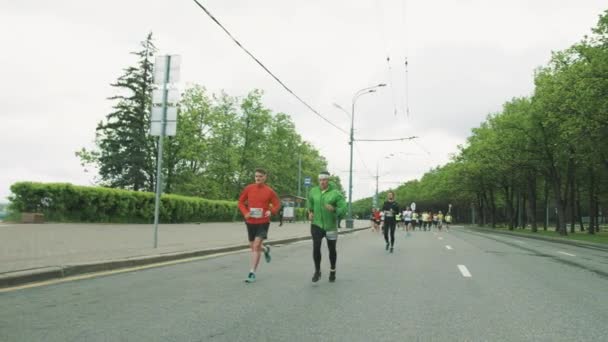 Grupp av sportiga idrottare maratonlopp på staden vägen längs b — Stockvideo