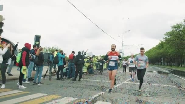 Cheerful athletes participate in marathon on wet asphalt covered — Stock Video