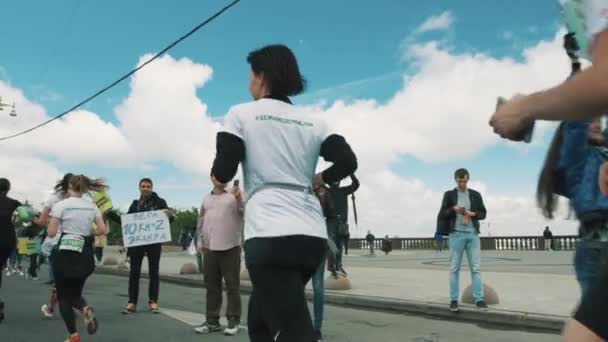 Personas con pancartas animando a los atletas corriendo maratón, porristas — Vídeo de stock