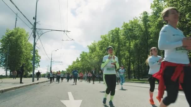 Толпа бегунов, бегущих марафон в красочной спортивной одежде — стоковое видео