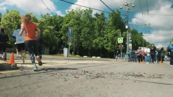 Confetti voando na encruzilhada da cidade enquanto atletas correndo maratona — Vídeo de Stock