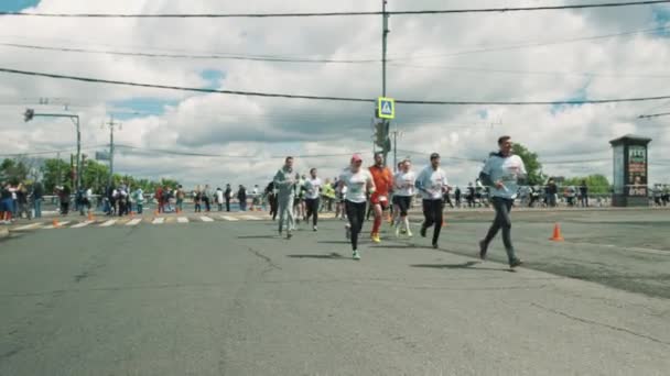 Веселые спортсмены бегут марафон размахивая и жестом перед камерой — стоковое видео