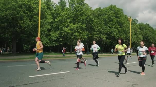 Веселая красивая девушка показывает энергетический бар, бегущий марафон — стоковое видео