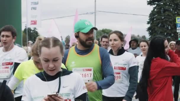 Atletas cansados multitud relajarse caminando después de la línea de meta maratón — Vídeo de stock
