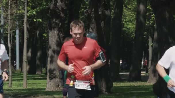 Уставший спортсмен бежит марафон в городском парке — стоковое видео