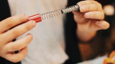 Erkek ellerini katlanmış çevresinde kırmızı plastik bahar aygıt merakla