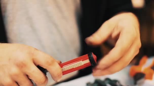 Mužské pracovník ruce šroubovák na červené trubky a rozbalení nové jaro — Stock video