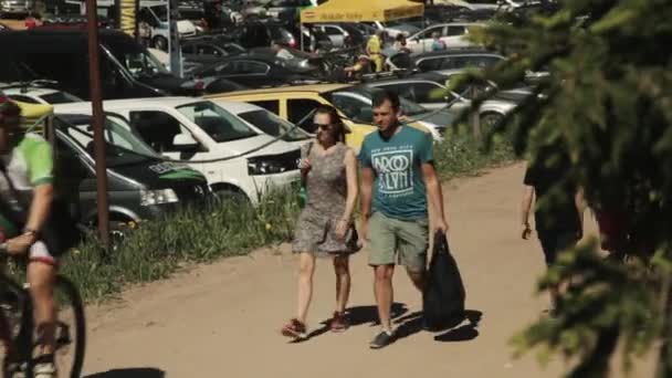 人们步行和骑自行车在路上沿停车场在 s — 图库视频影像
