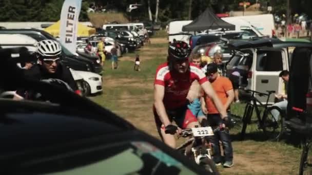 Sportolók meghajtók kerékpárok parkolóban sport erdőben még — Stock videók