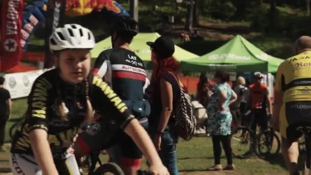 Mujer hablando con atleta en concurrida carrera de bicicleta evento deportivo — Vídeos de Stock