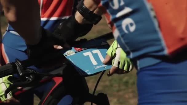 Sportsmen se une al número en la rueda de bicicleta en el evento de carreras deportivas — Vídeo de stock