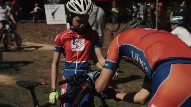 Sportsman tiras número em sua bicicleta filho no evento de corrida — Vídeo de Stock