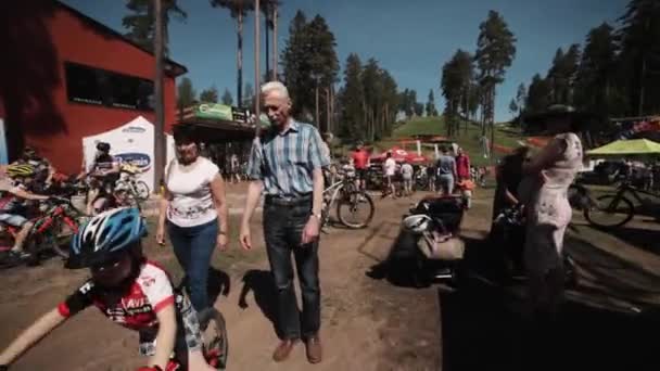 Jazda rowerem przez tłum ludzi na sportowe wydarzenie sportowe dla dzieci — Wideo stockowe