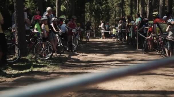 Маленькие дети на велосипедах участвуют в гонке в лесу — стоковое видео