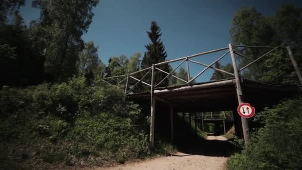 Freeride wielerwedstrijd in bos, atleet snel rijdt onder houten — Stockvideo