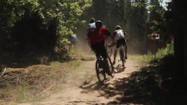 Cyklister som racing i skogen tar slå på dammig väg — Stockvideo