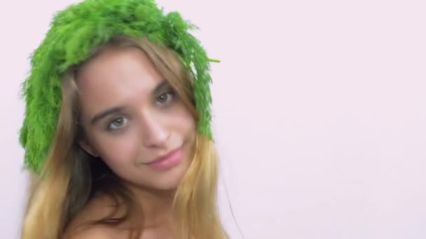 Chica joven con perejil verde en la cabeza vuelta y mirar en la cámara. Sonríe. Posando . — Vídeos de Stock