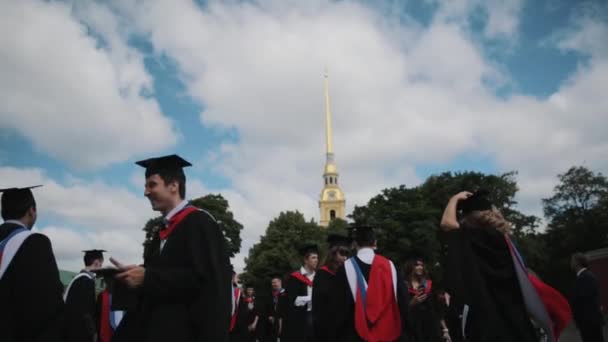 Grupo de estudiantes graduados pasando el rato en la plaza de la ciudad — Vídeo de stock