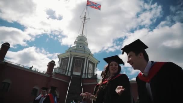 Grupo de estudiantes felices graduándose celebrando al aire libre en la ciudad — Vídeo de stock