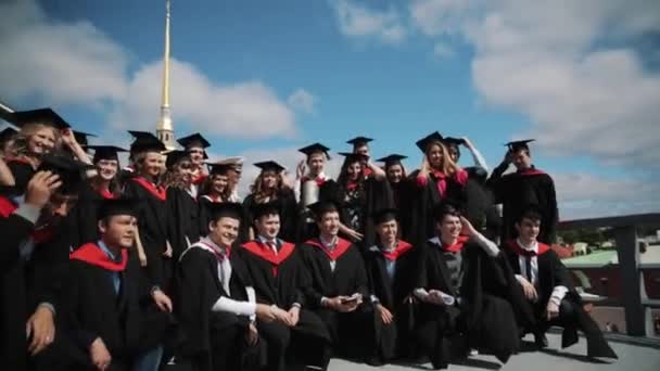 Groep opgewonden studenten afstuderen poseren voor foto buitenshuis ik — Stockvideo