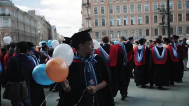 Joven asiático hombre en graduado celebración mirando alrededor celebración b — Vídeo de stock