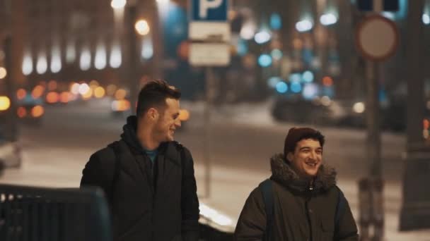 Twee jonge jongens lopen nacht stad straat in sneeuwval — Stockvideo