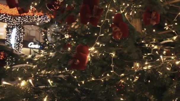 Juguetes de ardilla roja y guirnalda de luz blanca en el árbol de Navidad al aire libre — Vídeos de Stock