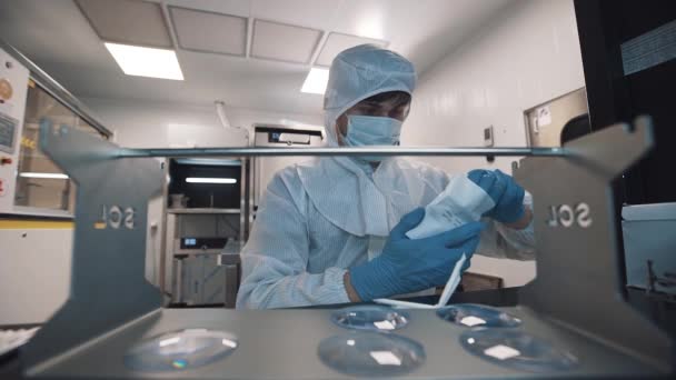 Оптиміст витягує лінзи і кладе їх на металевий стіл в лабораторію — стокове відео