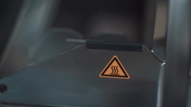 Metal kanca Makina Isı tehlike etiketi ile metal kutu içinde lensler koymak