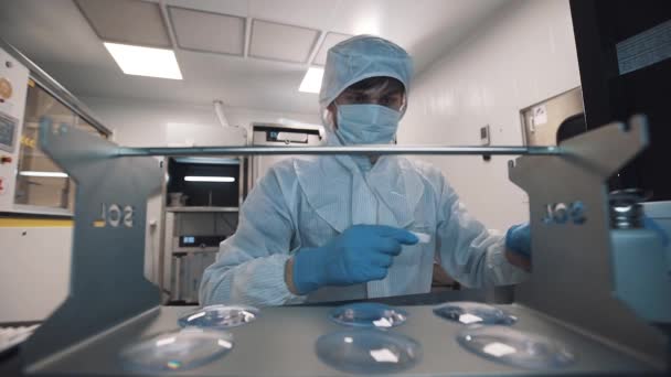 Vetenskapsman rengöra linser använder våt tygstycke på laboratorium — Stockvideo