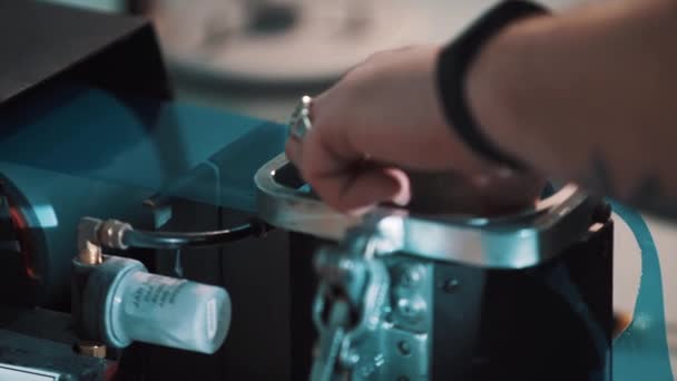 Linsenhersteller. Männerhände legen mit Verpackungsmaschine blaue Folie auf Linse — Stockvideo