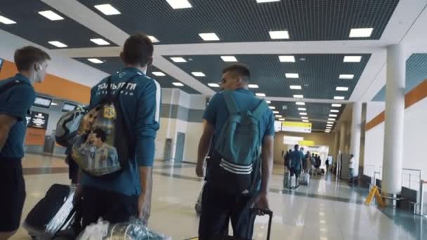 Группа молодых спортсменов, прогуливающихся по зданию аэропорта — стоковое видео