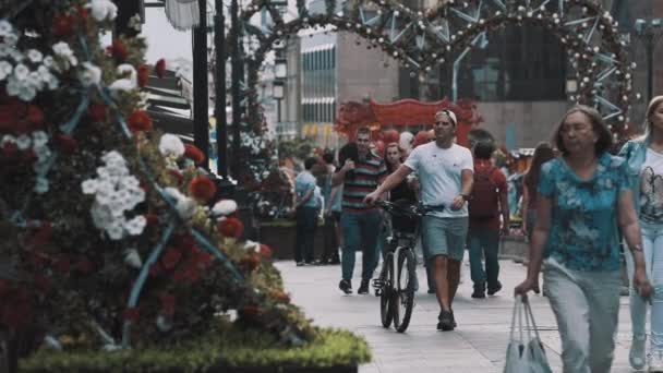 Verano evento sitio gente caminando a través de flores arco decorado — Vídeo de stock