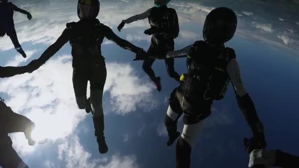 Gruppo di paracadutisti fanno formazione in cielo nuvoloso. Sport estremi. Giornata di sole . — Video Stock