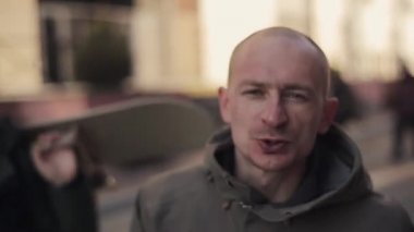 Snowboard ve kayakçılar sokakta yürümek ve cam içinde röportaj vermek