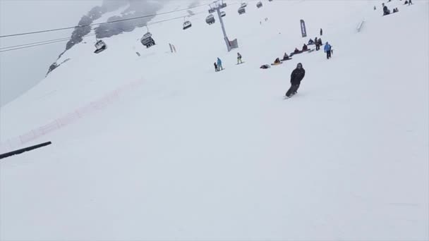 Snowboarder hacer extrema cincuenta cincuenta acrobacias en rieles en la montaña de nieve. Concurso. Desafío. Estación de esquí — Vídeos de Stock