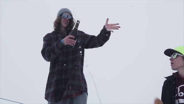 Snowboardista postřik champagne z trampolína na zasněžené hory. Soutěž. Výzva. Lyžařské středisko — Stock video